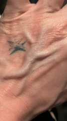 Hand with small black tattoo captured in London footage