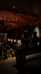 Dark restaurant interior with red-lit wooden beams captured in LA