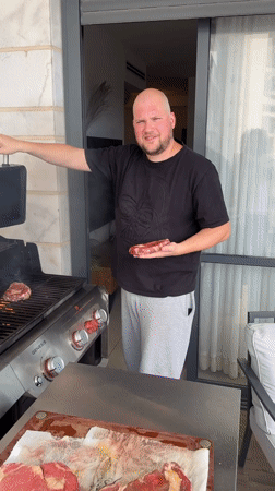 Man grills steaks on balcony in Ashkelon Friday afternoon