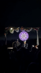 DJs perform nighttime set in San Diego beneath illuminated backdrop