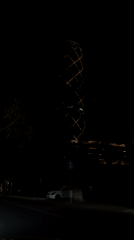 Tashkent's Pyramid Tower glows at night from a passing vehicle