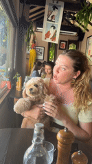 Woman shares breakfast with small dog at Indonesian cafe