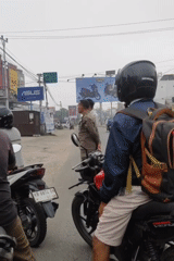 Morning motorcycle traffic near a hospital in Sintang, Indonesia
