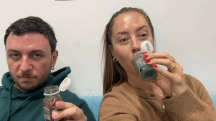 London pair shares juice drinks in casual indoor setting