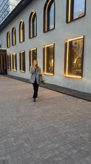 Woman walks brick sidewalk in Krasnoyarsk carrying tote bag