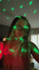 Girl dances enthusiastically in colorful lights in Esenyurt home