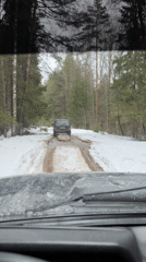 Vehicles traverse muddy forest tracks in snowy Russian woodland