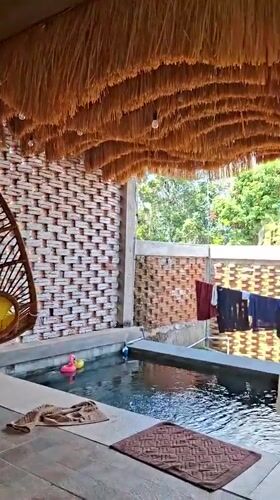 Thatched villa poolside with hanging chair, Kuta Selatan