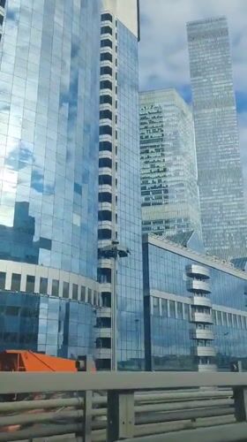 Driving past Moscow City's glass skyscraper cluster on a cloudy day