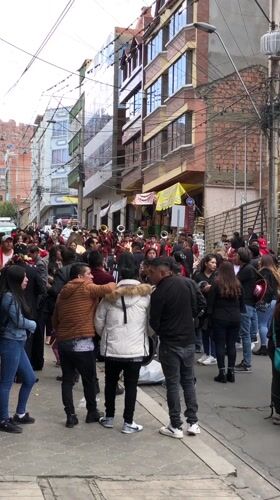 Marching band in red suits parades through La Paz streets