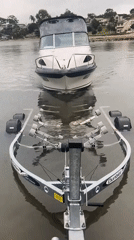 Paddlewheel boat on a river, another getting trailered out