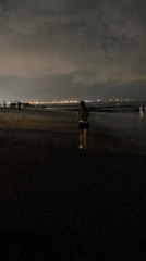 Woman walks barefoot on Bali beaches during overcast morning