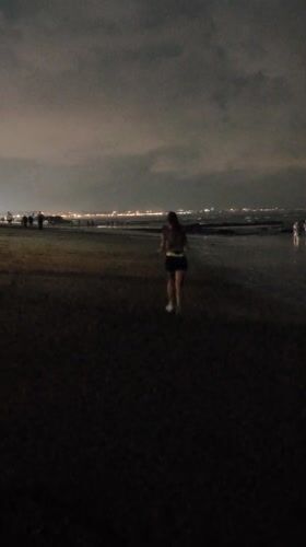 Woman walks barefoot on Bali beaches during overcast morning