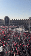 Large crowd with flags gathers at Tehran plaza