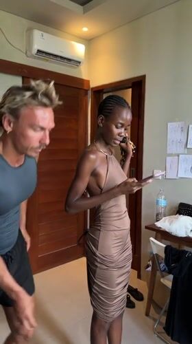 Man adjusts woman's dress during phone call in Mengwi
