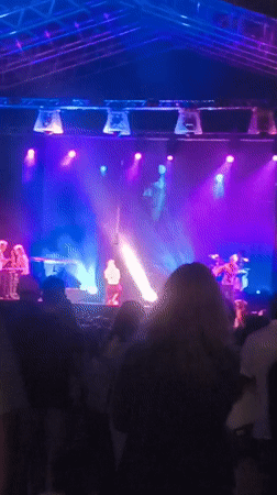 Live band plays under purple-blue lights at outdoor Vitoria-Gasteiz concert