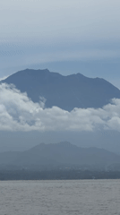 Cloudy mountain landscape captured along Indonesian waterfront at dawn