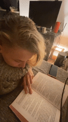 Person reads book on couch in Lobnya, Russia