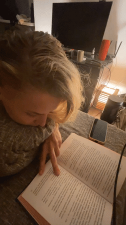 Person reads book on couch in Lobnya, Russia