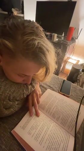 Person reads book on couch in Lobnya, Russia