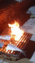 Man grills fresh fish over open fire in Juan Griego