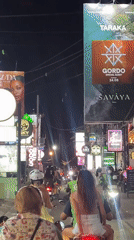 Nighttime motorcycle traffic flows through busy North Kuta streets