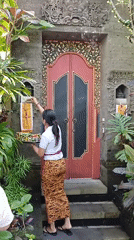 Woman performs traditional Hindu offerings at Ubud shrines