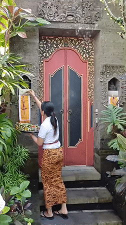 Woman performs traditional Hindu offerings at Ubud shrines