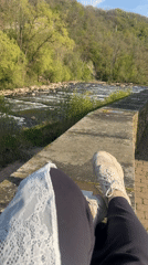 Person relaxes by river in Meisenheim, Germany