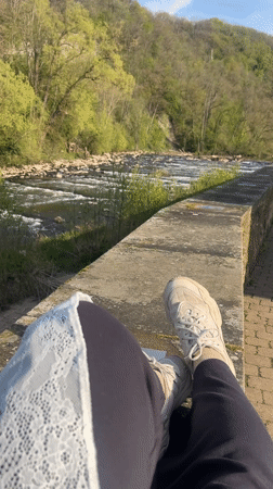 Person relaxes by river in Meisenheim, Germany