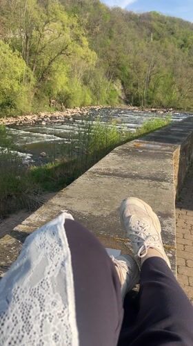 Person relaxes by river in Meisenheim, Germany