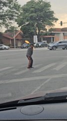 Man juggles flaming batons while crossing street in Puebla