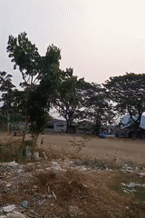 Neighborhood activity around a dirt lot in Karawang