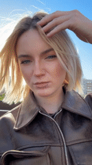 Woman in leather jacket photographed outdoors in sunny weather