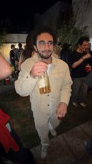 Young men socialize at outdoor party with drinks