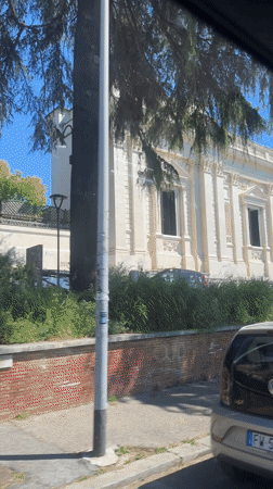 Car passes classical government building in Rome