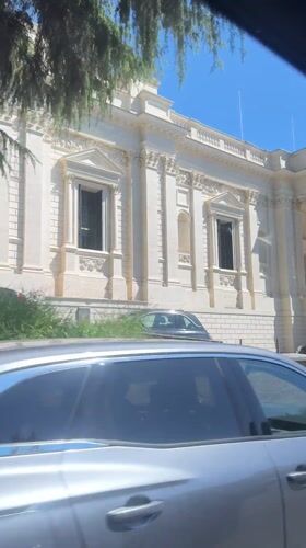 Car passes classical government building in Rome