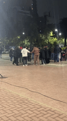 Circle dancers gather on Cordoba plaza at night