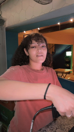 Young man plays guitar, woman reads on couch in São Paulo