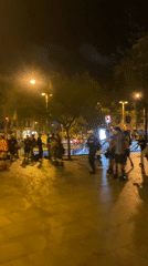 Night rollerblading group gathers in illuminated Barcelona plaza