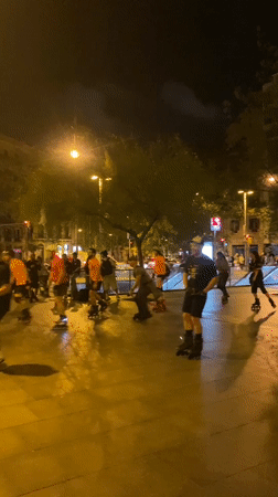 Night rollerblading group gathers in illuminated Barcelona plaza