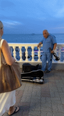 Violinist plays Sochi's Black Sea promenade at sunset