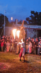 Fire dancer entertains crowd alongside stilt walker in Bulgaria