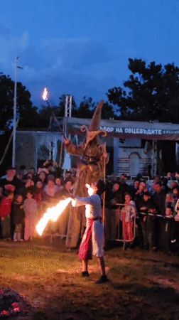 Fire dancer entertains crowd alongside stilt walker in Bulgaria