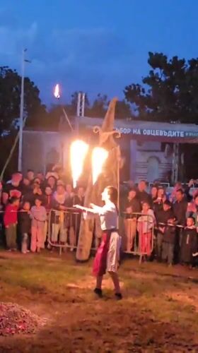 Fire dancer entertains crowd alongside stilt walker in Bulgaria