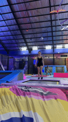 Woman uses trampoline at indoor park in Denpasar