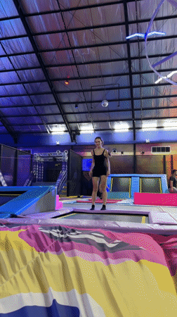Woman uses trampoline at indoor park in Denpasar