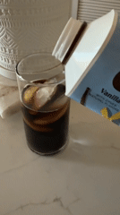 Person pours beverage from blue container in San Diego kitchen
