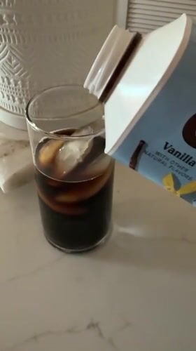 Person pours beverage from blue container in San Diego kitchen