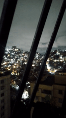 Nighttime cityscape captured across Caracas under cloudy skies